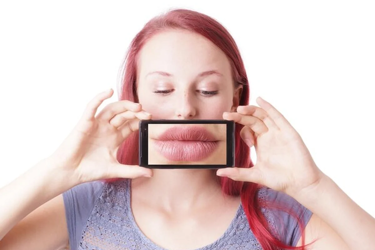 Kobieta wykonująca zdjęcie swoich ust podczas domowego powiększania - jak unikać błędów?