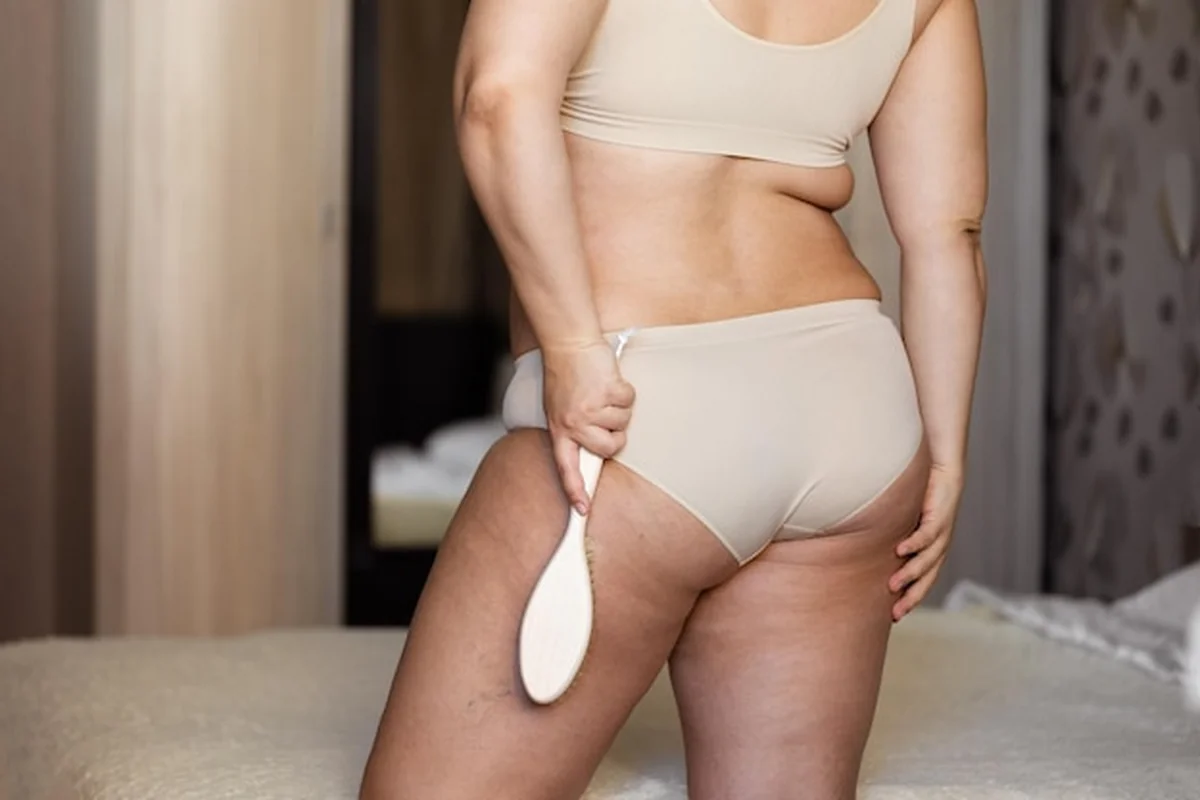 Kobieta w dużych rozmiarach masująca nogi szczotką, unikalny sposób walki z cellulitem