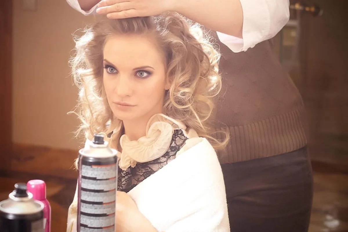 Blond kobieta w salonie fryzjerskim przy Fryzjer na tle Hollywood Hair's cennika