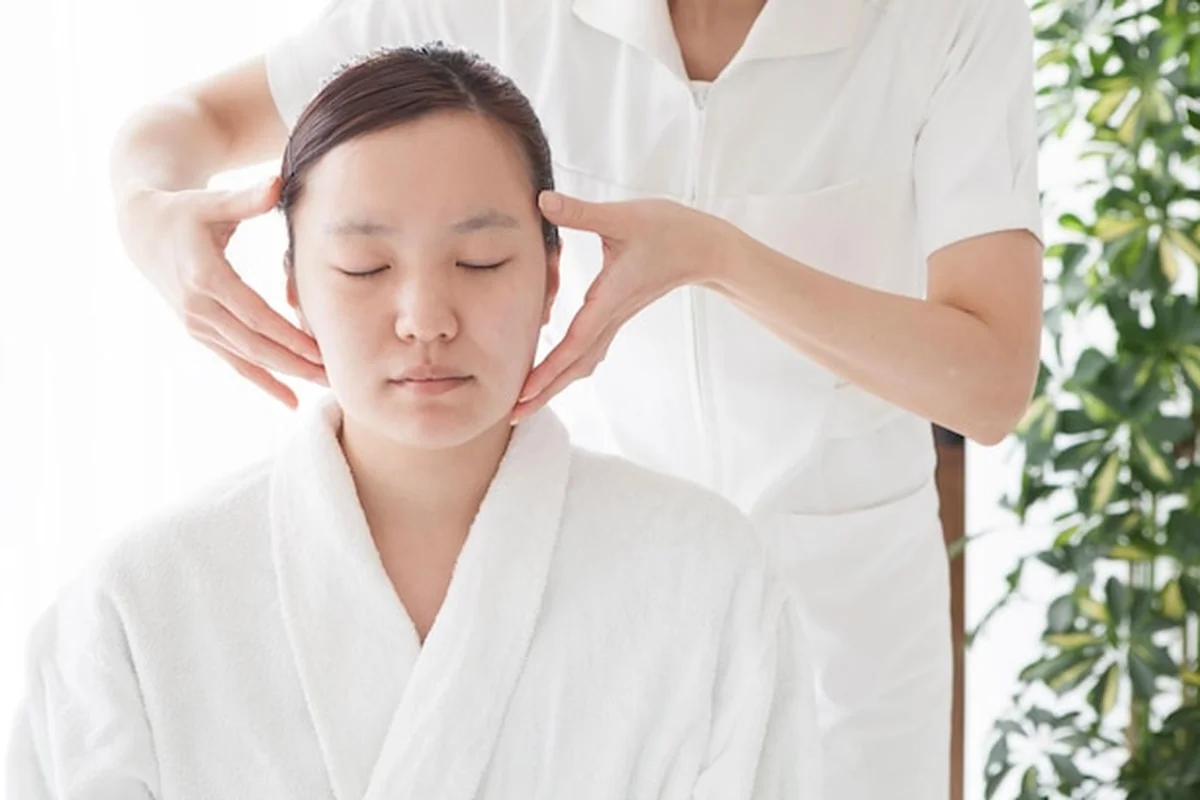 Kobieta otrzymuje masaż kobido w spa, japoński rytuał wyróżniający się spośród innych masaży twarzy