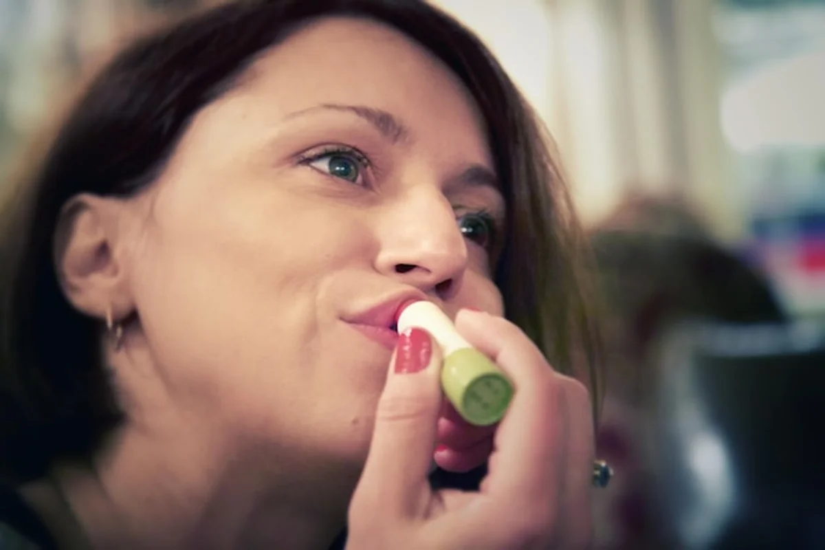 Kobieta aplikująca szminkę naturalnymi metodami poprawiającymi kondycję ust. Jak wspierać zdrowie warg?