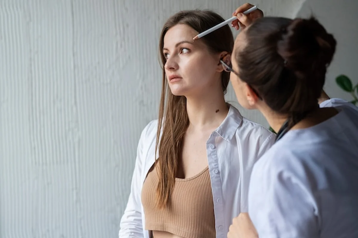 Lekarka diagnozująca zmiany skórne na ciele pacjentki po zabiegu PMU