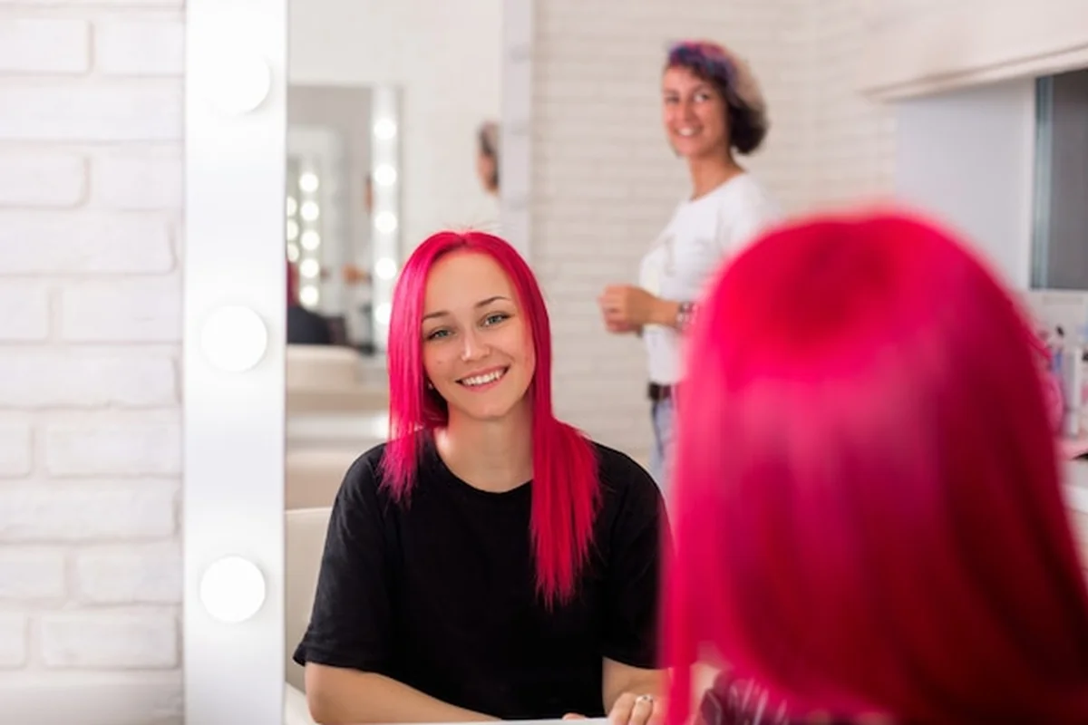 Młoda kobieta w salonie fryzjerskim dbająca o nowy kolor włosów po koloryzacji
