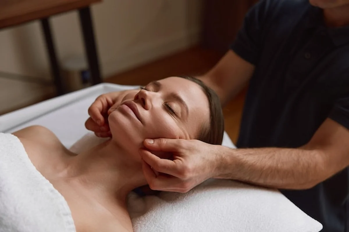 Kobieta otrzymuje masaż twarzy w luksusowym salonie spa. Czytaj o przeciwwskazaniach do masażu kobido