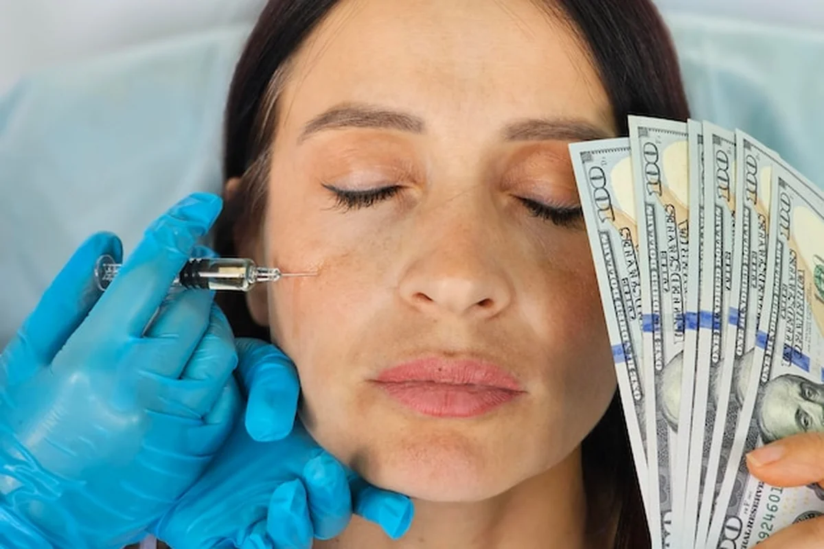 Kobieta otrzymuje mezoterapię w twarz, trzymając dolary amerykańskie. Jaka jest cena i co wpływa na jej wysokość?
