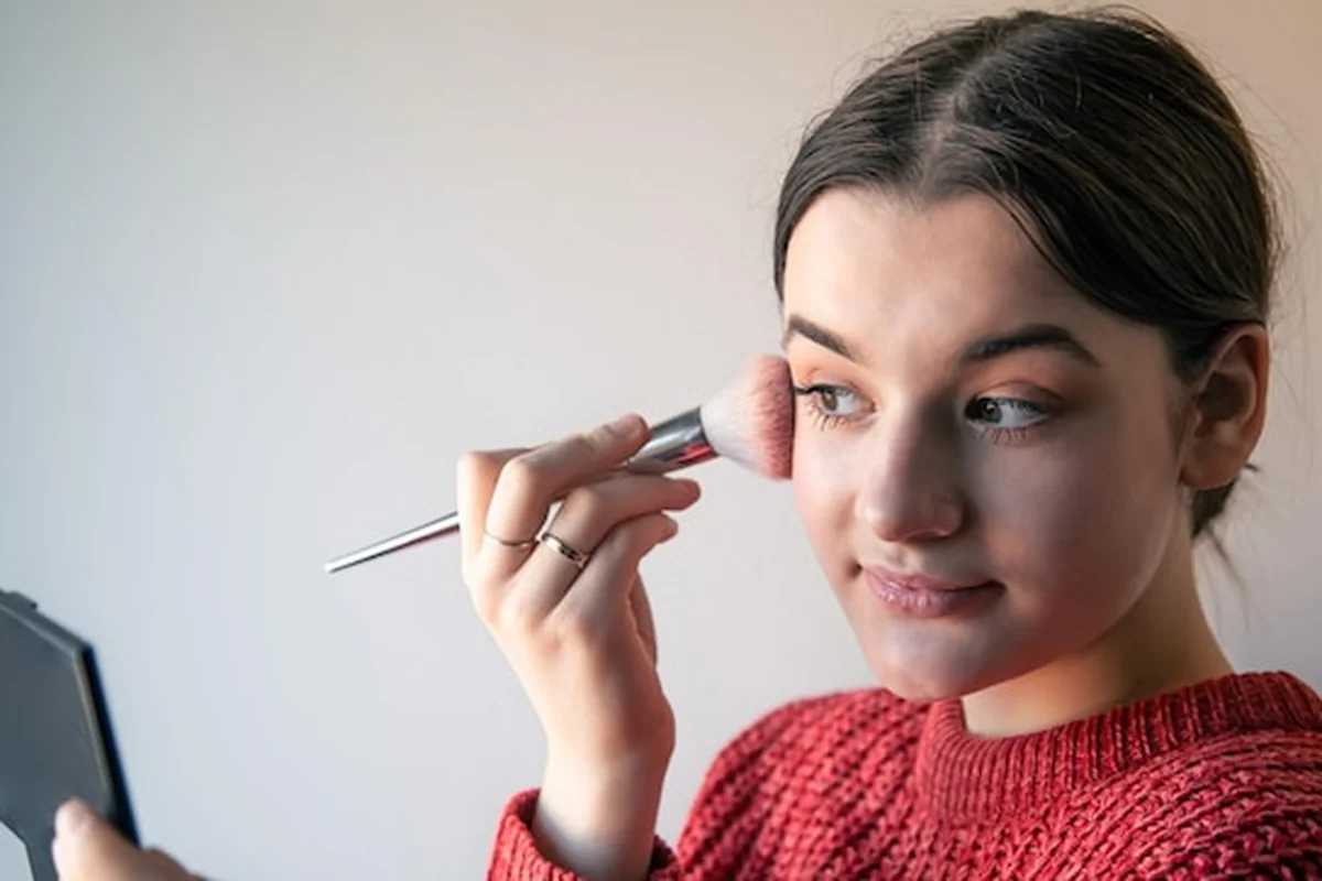 Młoda kobieta poddająca się zabiegowi makijażu permanentnego za pomocą pędzli